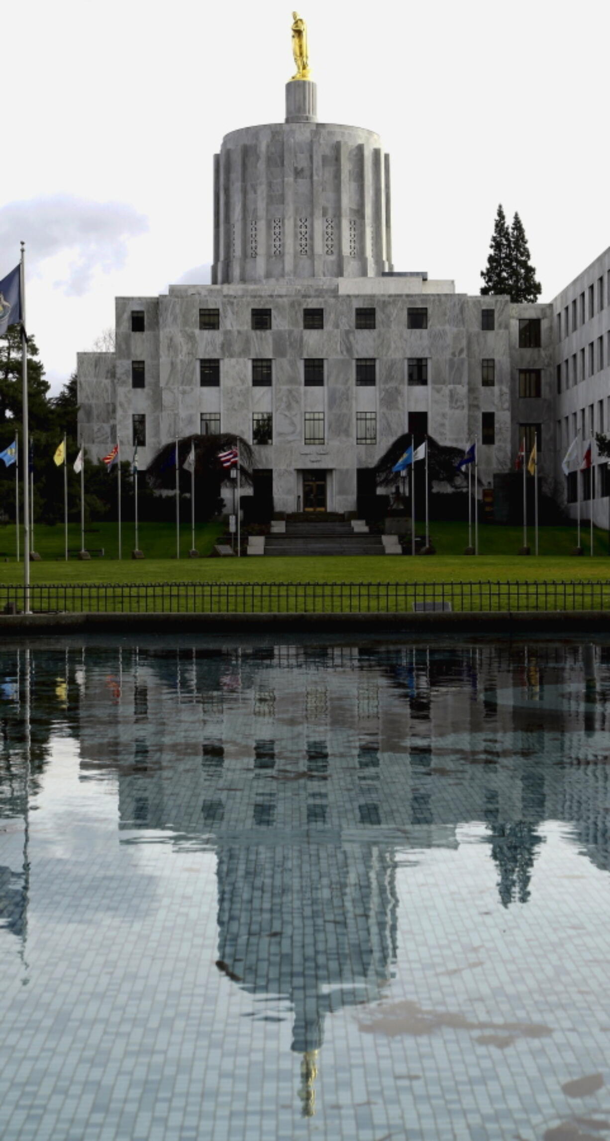 FILE - In this Feb. 2, 2015, file photo, the Capitol building is reflected in a pond on the Capitol grounds in Salem, Ore. Tensions are high at the Capitol after the Democratic speaker of the Oregon House rescinded a power-sharing deal she made with Republicans to redraw political maps.