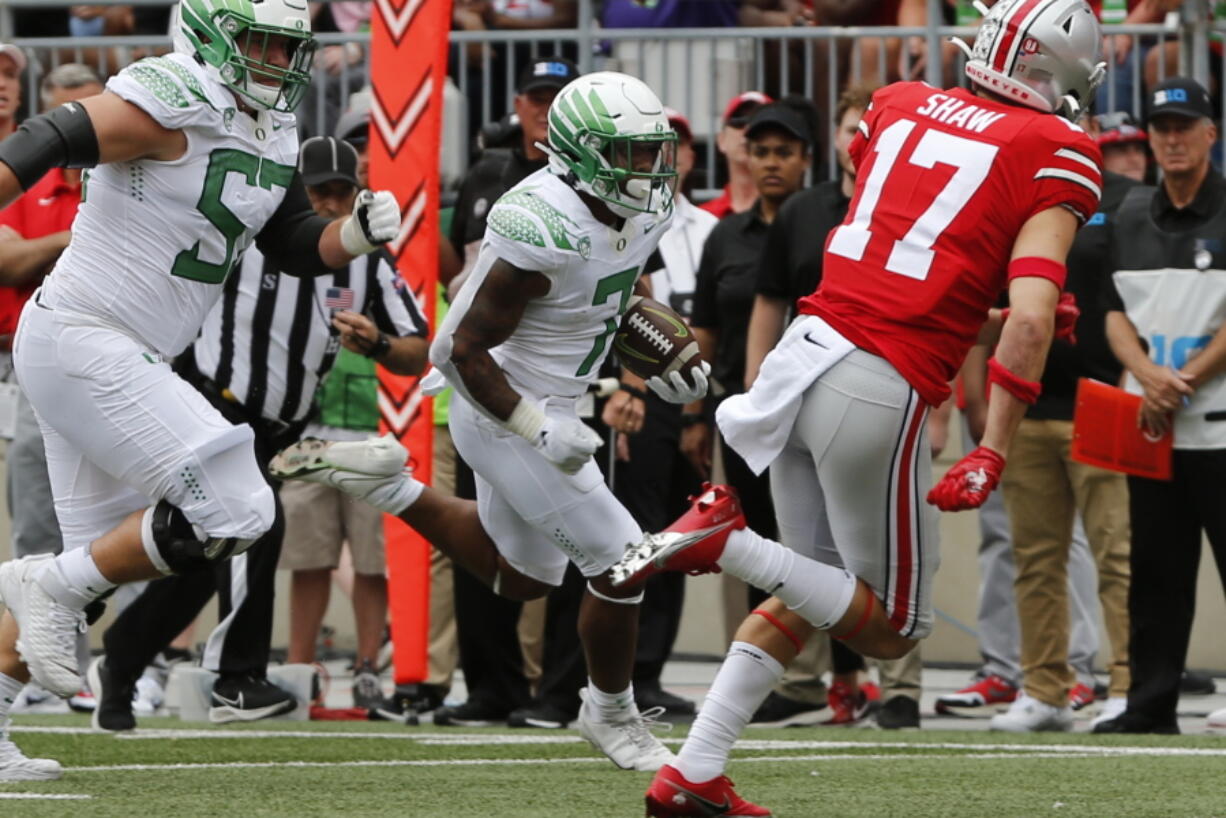 Oregon running back CJ Verdell, center, scores a touchdown against Ohio State during the first half of an NCAA college football game Saturday, Sept. 11, 2021, in Columbus, Ohio.