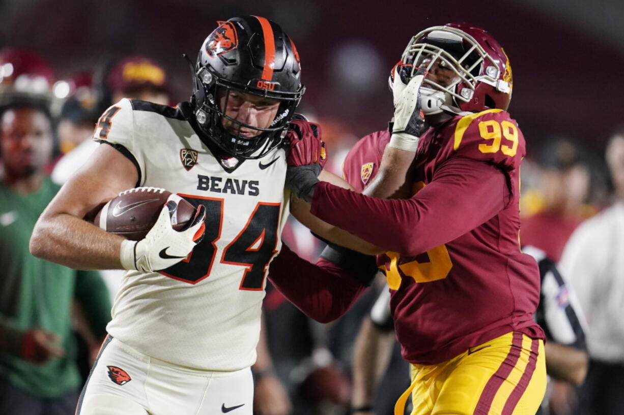 Oregon State tight end Teagan Quitoriano (84) stiff-arms Southern California linebacker Drake Jackson (99) after a reception during the second half of an NCAA college football game Saturday, Sept. 25, 2021, in Los Angeles.