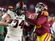 Oregon State tight end Teagan Quitoriano (84) stiff-arms Southern California linebacker Drake Jackson (99) after a reception during the second half of an NCAA college football game Saturday, Sept. 25, 2021, in Los Angeles.