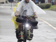 With the rain falling, a bicyclist dressed in wet weather gear travels along the Great Allegheny Passage near the McKeesport Hostel Tuesday, Aug. 31, 2021, in McKeesport, Pa.