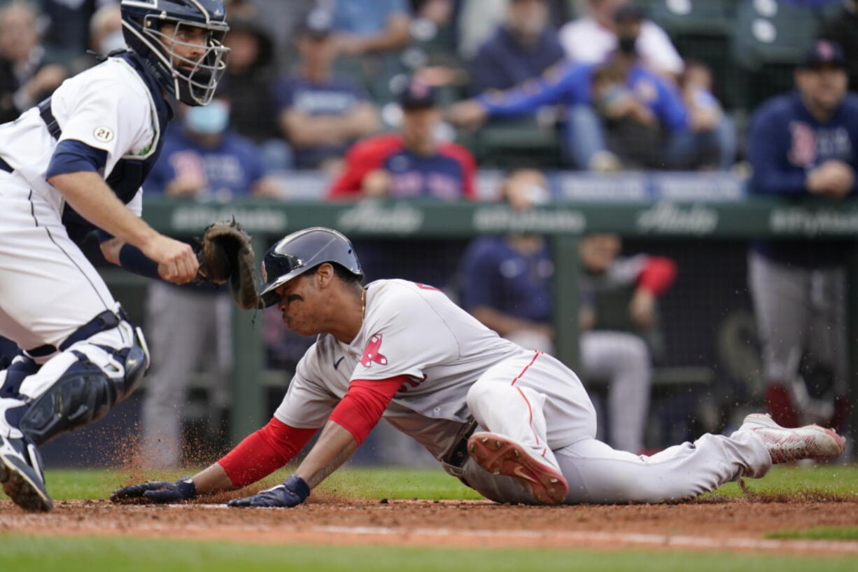 Boston Red Sox's Rafael Devers, right, scores as Seattle Mariners catcher Tom Murphy waits for the ball in the 10th inning of a baseball game Wednesday, Sept. 15, 2021, in Seattle.