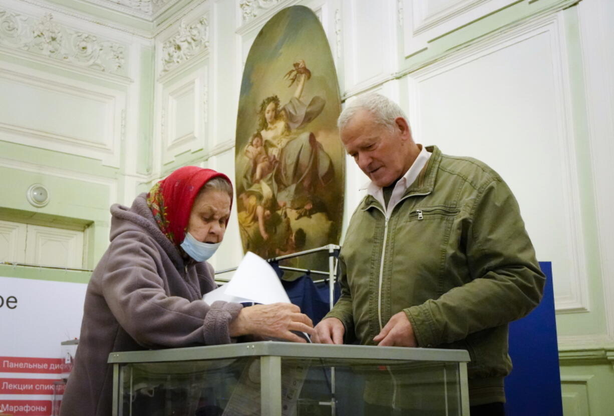 People cast their ballots during the State Duma, the Lower House of the Russian Parliament and local parliaments elections at a polling station situated in an old palace in St. Petersburg, Russia, Saturday, Sept. 18, 2021. Sunday will be the last of three days voting for a new parliament, but there seems to be no expectation that United Russia, the party devoted to President Vladimir Putin, will lose its dominance in the State Duma.