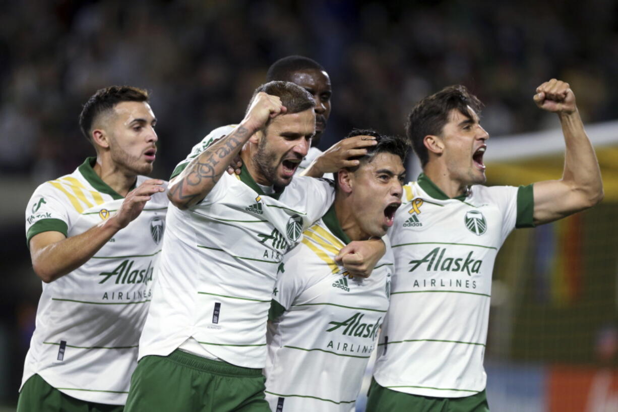 Portland Timbers forward Felipe Mora, second from right, and teammates celebrate his second-half goal against the Colorado Rapids during an MLS soccer match Wednesday, Sept. 15, 2021, in Portland, Ore.