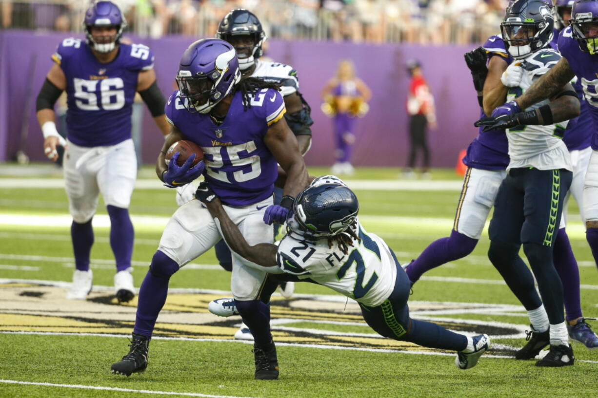 Minnesota Vikings running back Alexander Mattison (25) is tackled by Seattle Seahawks cornerback Tre Flowers (21) in the first half of an NFL football game in Minneapolis, Sunday, Sept. 26, 2021.