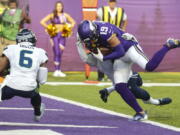 Minnesota Vikings wide receiver Adam Thielen (19) scores a touchdown on a catch in front of Seattle Seahawks strong safety Quandre Diggs (6) in the first half of an NFL football game in Minneapolis, Sunday, Sept. 26, 2021.