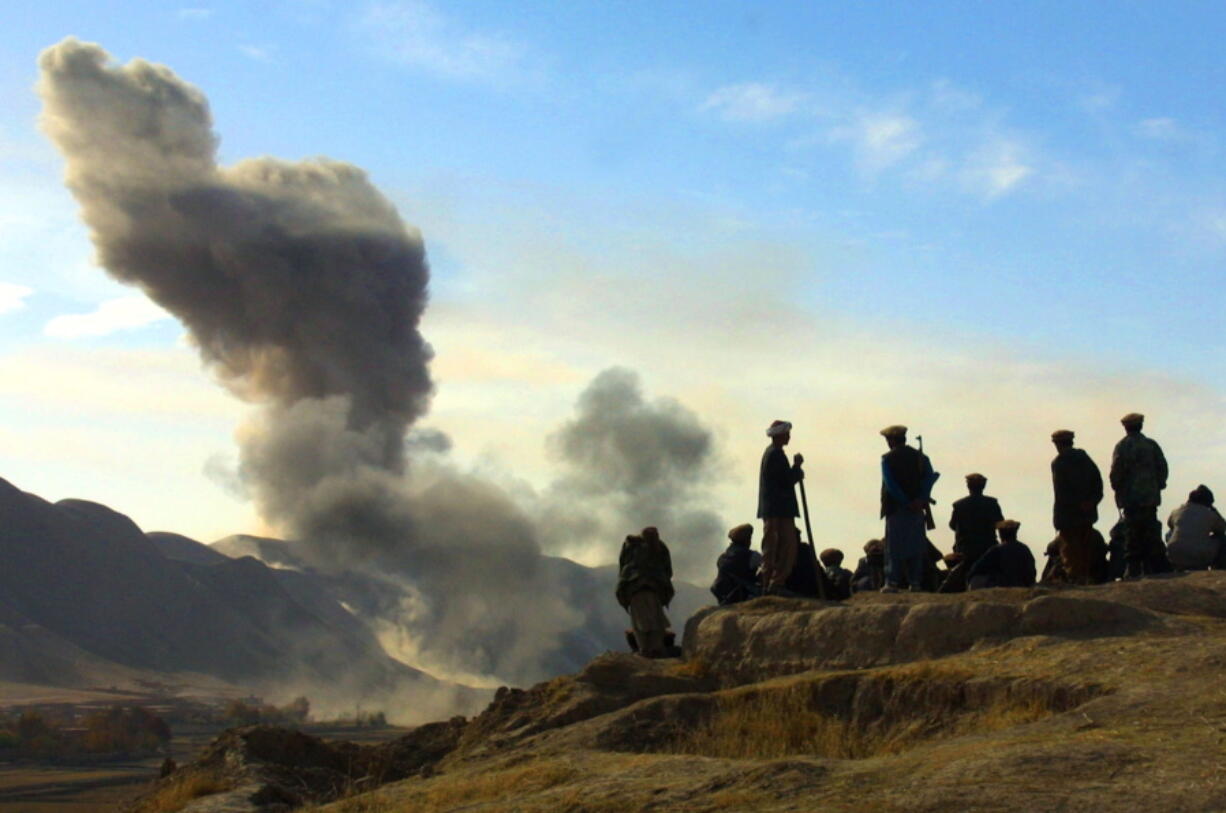 FILE - In this Nov. 19, 2001 file photo, Northern Alliance soldiers watch as U.S. air strikes attack Taliban positions in Kunduz province, Afghanistan.