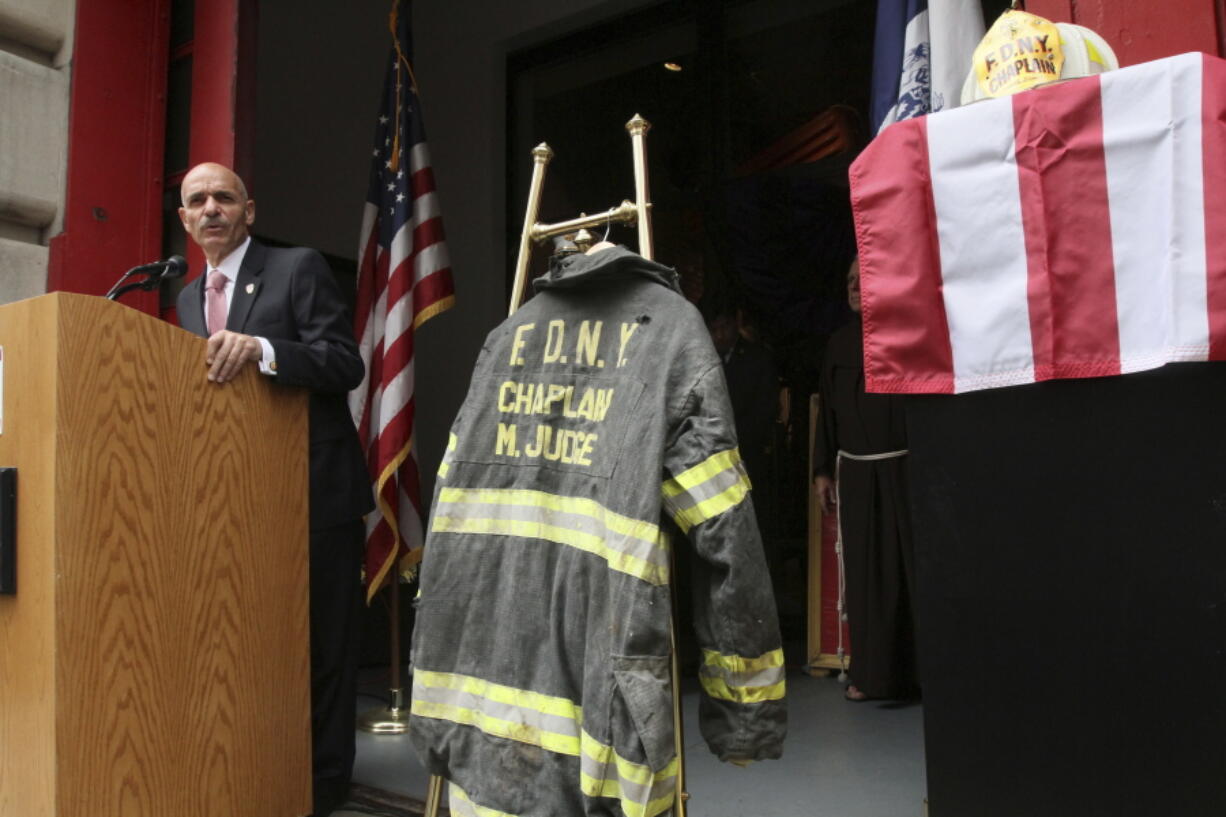 The bunker coat and helmet worn by FDNY Chaplain Mychal Judge are displayed Sept. 11, 2011, as city of New York Fire Commissioner Salvatore J. Cassano speaks at the New York City Fire Museum in New York during a memorial ceremony for the 343 members of the FDNY who lost their lives in the World Trade Center attacks.