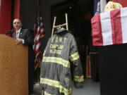 The bunker coat and helmet worn by FDNY Chaplain Mychal Judge are displayed Sept. 11, 2011, as city of New York Fire Commissioner Salvatore J. Cassano speaks at the New York City Fire Museum in New York during a memorial ceremony for the 343 members of the FDNY who lost their lives in the World Trade Center attacks.