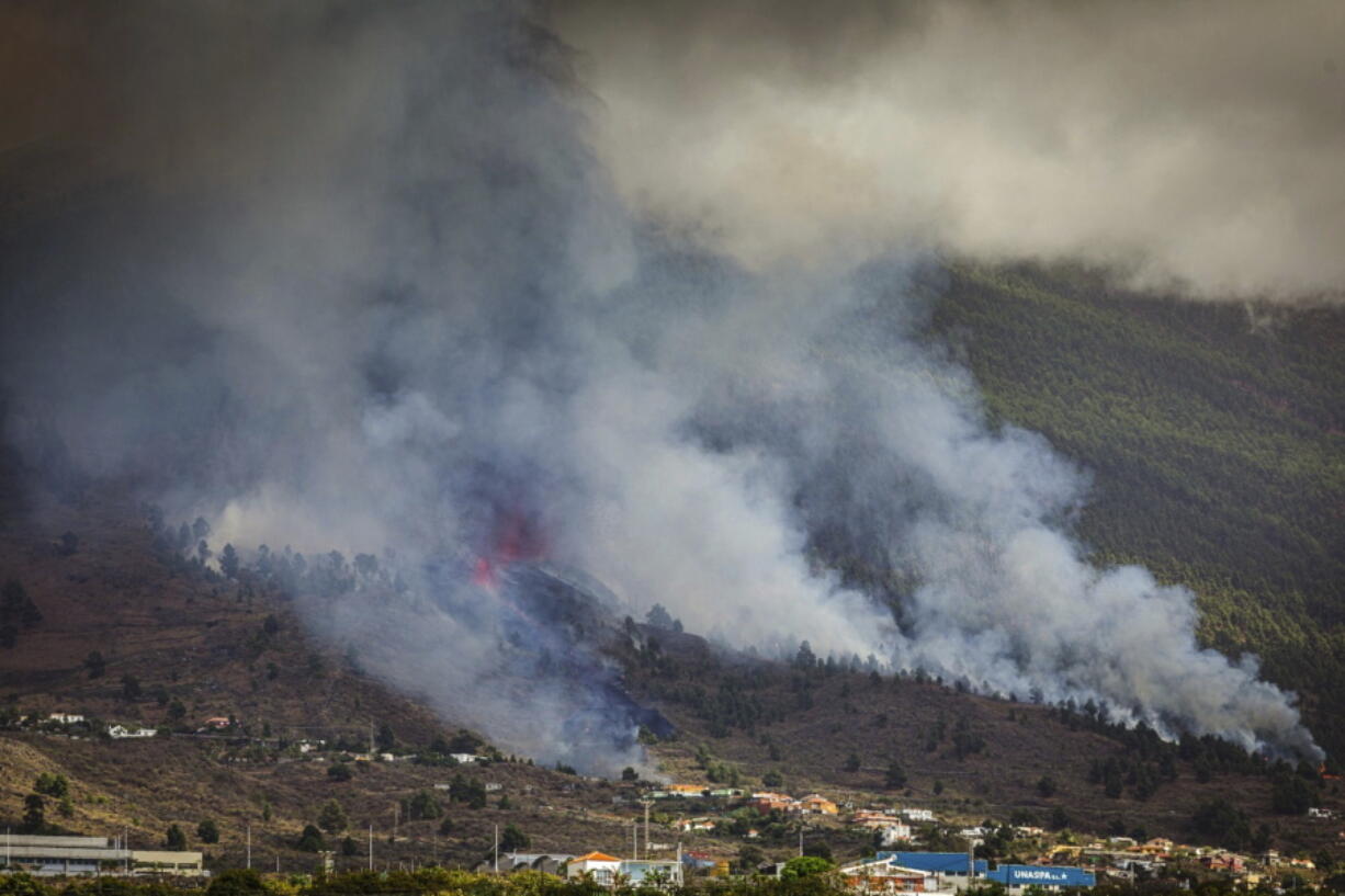 Smoke rises at the Cumbre Viegja volcanic on the island of La Palma in the Canaries, Spain, Sunday, Sept. 19, 2021. A volcano on Spain's island of La Palma eruption Sunday after a weeklong buildup of seismic activity, prompting authorities to start an evacuation plan expected to effect around 1,000 people.