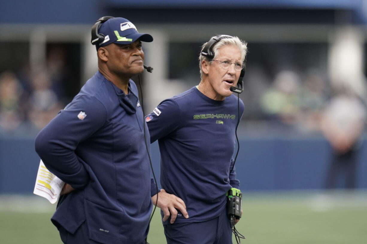 Seattle Seahawks head coach Pete Carroll, right, stands with defensive coordinator Ken Norton Jr., left, stand on the sidelines during Sunday's game against the Tennessee Titans in Seattle.