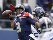 Seattle Seahawks quarterback Russell Wilson is pressured by Tennessee Titans outside linebacker Bud Dupree, right, late in the fourth quarter.