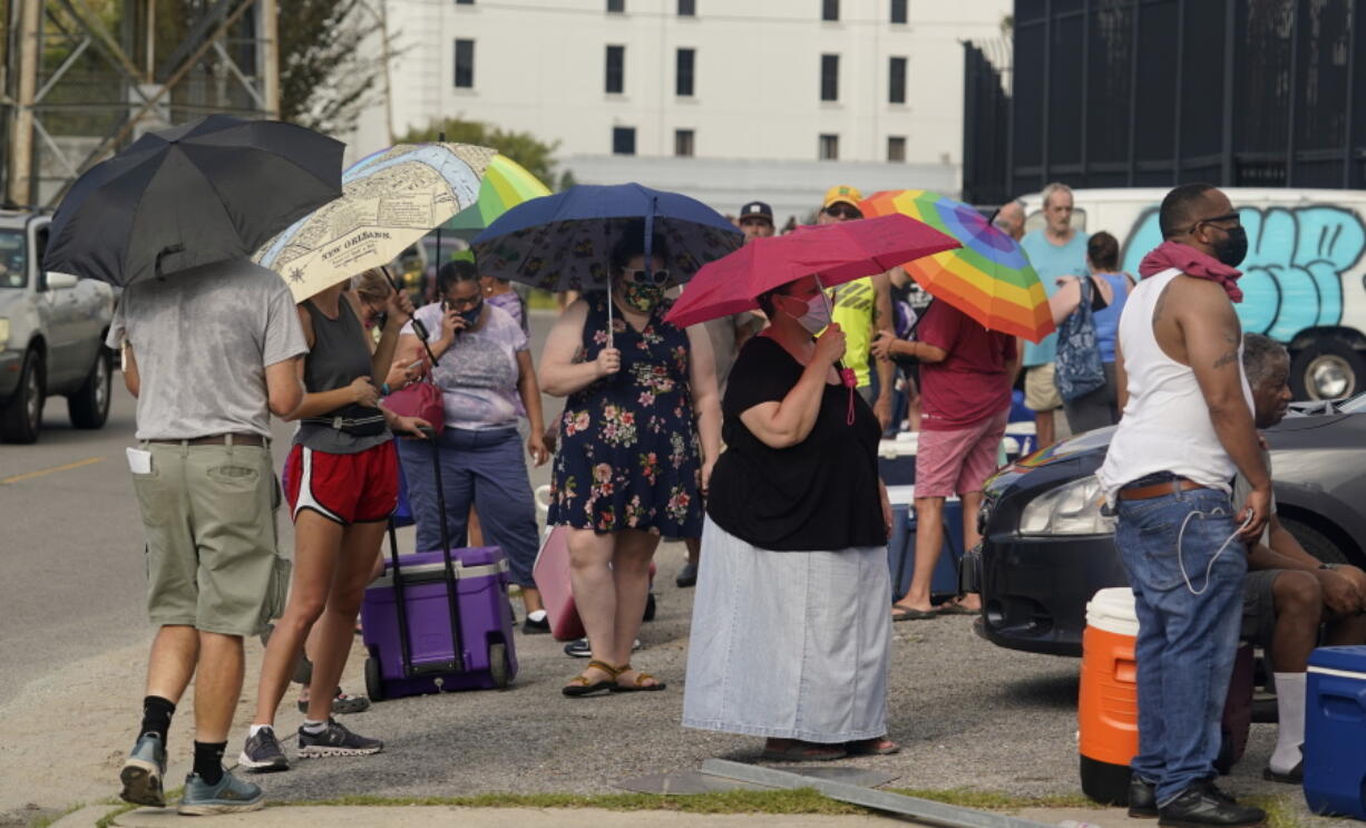 In the aftermath of Hurricane Ida people line up for food and ice at a distribution center Wednesday, Sept. 1, 2021, in New Orleans, La.  Louisiana residents still reeling from flooding and damage caused by Hurricane Ida are scrambling for food, gas, water and relief from the oppressive heat.