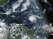 This satellite image provided by the National Oceanic and Atmospheric Administration shows Hurricane Sam, just right of center, in the Atlantic Ocean, Monday, Sept. 27, 2021, at 1920 Zulu (3:20 p.m. ET). Sam is a powerful Category 4 storm but it poses no threat to land as it loops northward in the Atlantic, according to the U.S. National Hurricane Center.