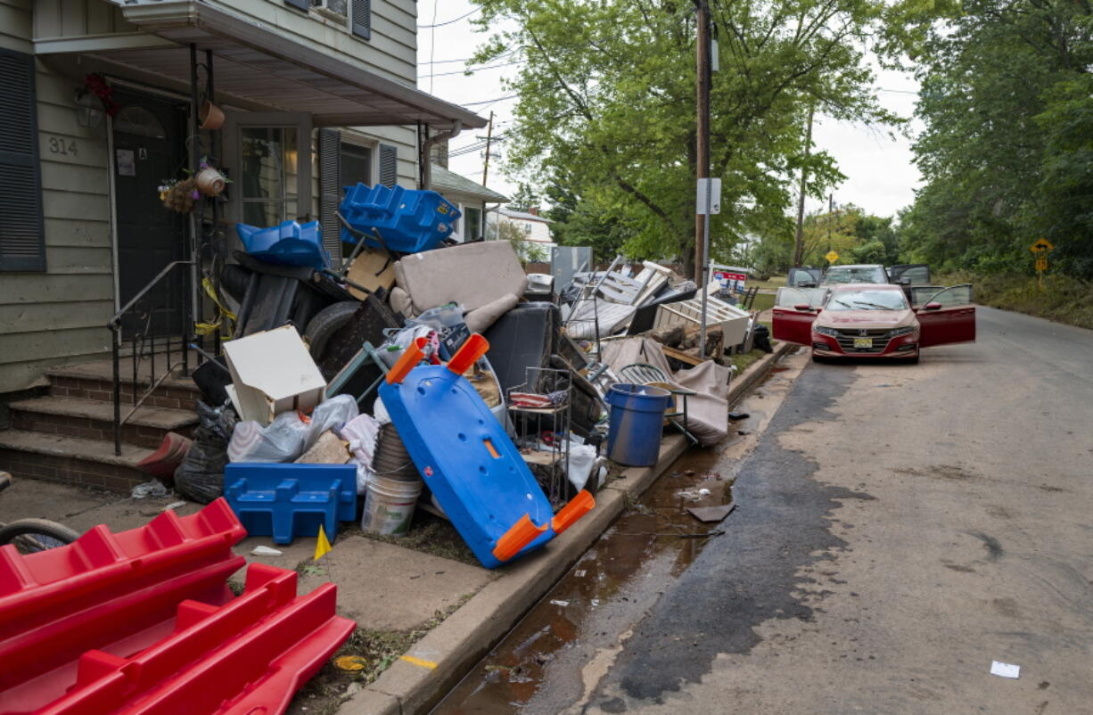 Debris from flood damage caused by the remnants of Hurricane Ida lies on the side of a street in Manville, N.J., Sunday, Sept. 5, 2021. Flood-stricken families and business owners across the Northeast are hauling waterlogged belongings to the curb and scraping away noxious mud as cleanup from Ida moves into high gear.