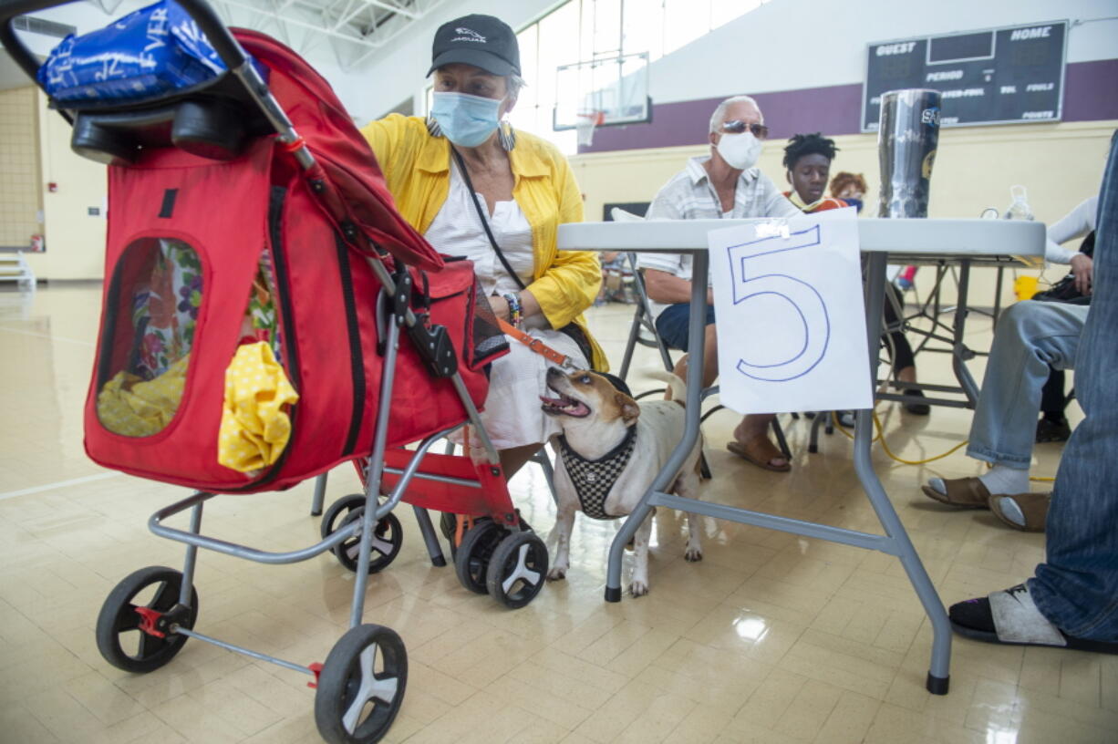 Viana Chacol, 65, and her dog, Chanel, rest at a cooling shelter at the Treme Recreation Community Center in New Orleans, La., Thursday, Sept. 2, 2021. The facility features water, charging stations, bathrooms, food, and other basic services to help residents after Hurricane Ida.