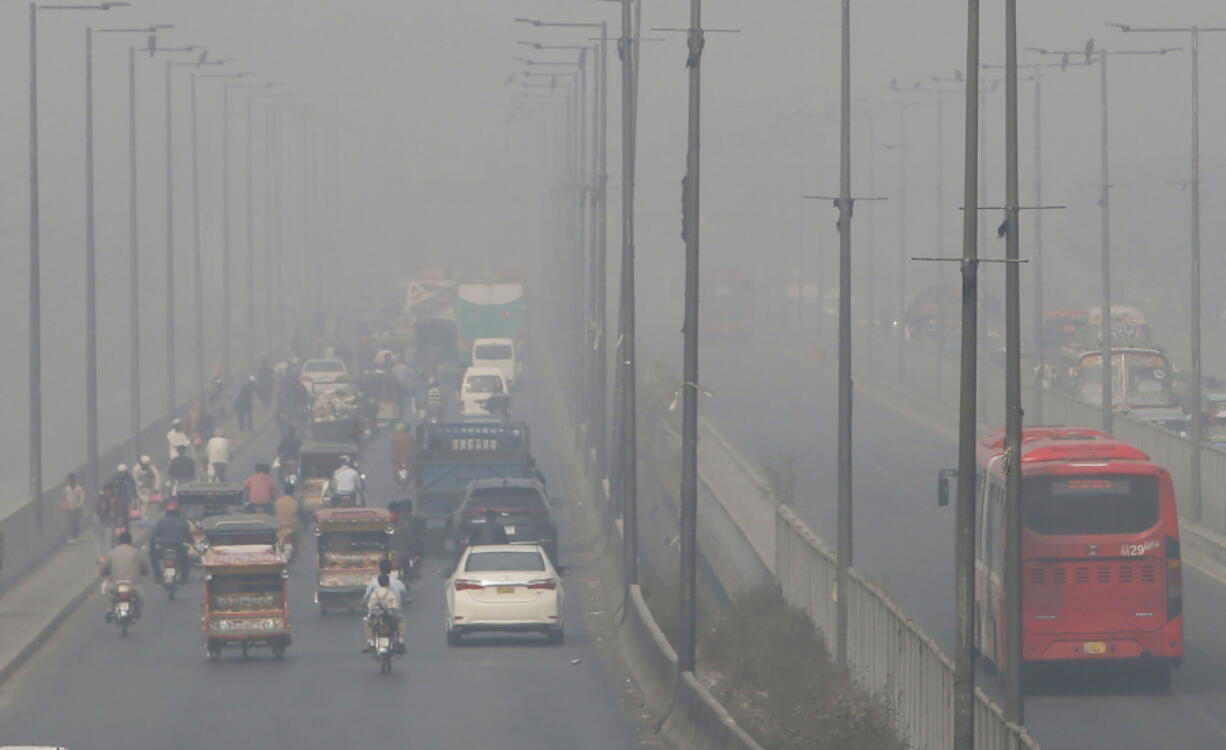 FILE - In this Wednesday, Nov. 11, 2020 file photo, vehicles drive on a highway as smog envelops the area of Lahore, Pakistan. The World Health Organization said Wednesday Sept. 22, 2021, the negative health impacts of poor air quality kick in at lower levels than it previously thought, announcing revisions to its guidelines on air quality that set a higher bar for policymakers in a world where 90 percent of people already live in areas with one particularly harmful type of pollutant. (AP Photo/K.M.