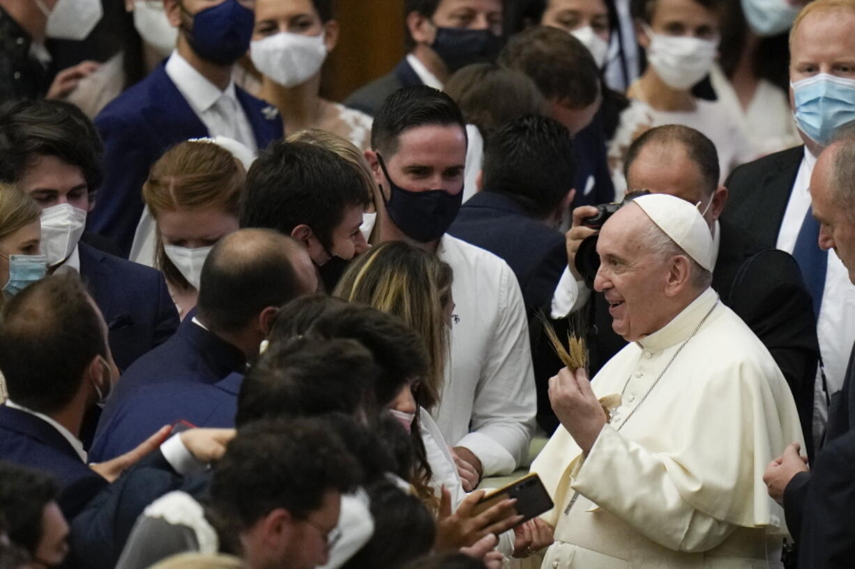 Pope Francis holds an ear of corn presented by a pilgrim as he leaves after his weekly general audience in the Paul VI Hall at the Vatican, Wednesday, Sept. 29, 2021.