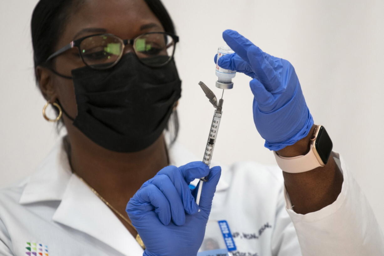 FILE - In this Dec. 21, 2020, file photo, Michelle Chester, director of employee health services at Northwell Health, prepares the Moderna COVID-19 vaccine at Northwell Health's Long Island Jewish Valley Stream hospital in Valley Stream, N.Y. Hospitals and nursing homes across the country are preparing for worsening staff shortages as state deadlines arrive for employees to get vaccinated against COVID-19. New York health care employees had until the end of the day Monday, Sept. 27, 2021, to get at least one dose.