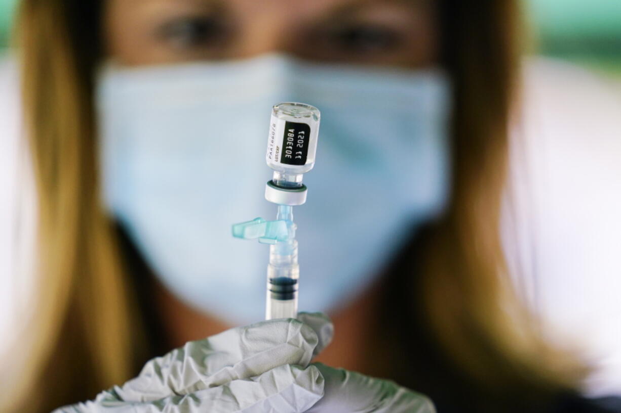 FILE - In this Sept. 14, 2021, file photo, a syringe is prepared with the Pfizer COVID-19 vaccine at a clinic at the Reading Area Community College in Reading, Pa. COVID-19 deaths and cases in the U.S. have climbed back to where they were over the winter, wiping out months of progress and potentially bolstering President Joe Biden's case for sweeping new vaccination requirements.