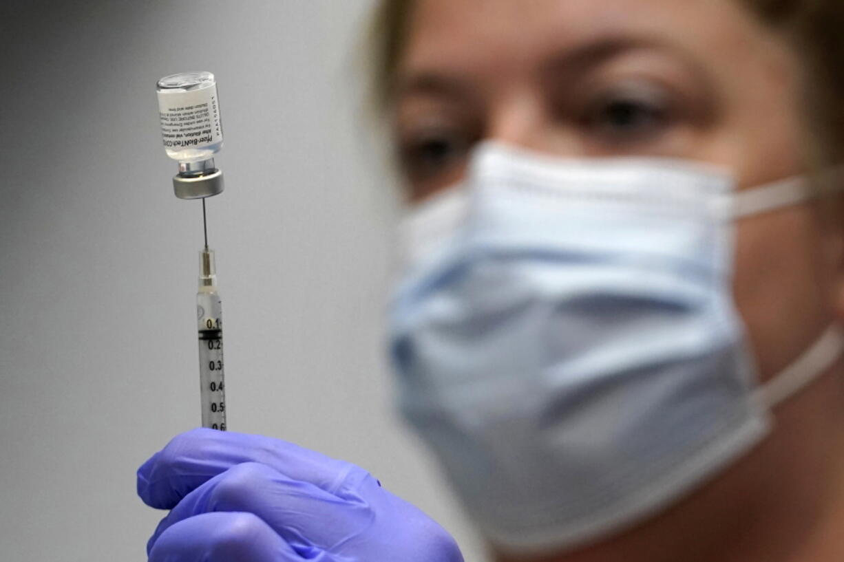 FILE - In this March 2, 2021, file photo, Hollie Maloney, a pharmacy technician, loads a syringe with Pfizer's COVID-19 vaccine at the Portland Expo in Portland, Maine. An influential federal advisory panel overwhelmingly rejected a plan Friday, Sept. 17, to offer Pfizer booster shots against COVID-19 to most Americans, dealing a heavy blow to the Biden administration's effort to shore up people's protection amid the highly contagious delta variant. (AP Photo/Robert F.