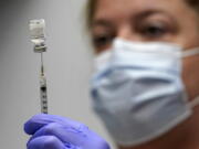 FILE - In this March 2, 2021, file photo, Hollie Maloney, a pharmacy technician, loads a syringe with Pfizer's COVID-19 vaccine at the Portland Expo in Portland, Maine. An influential federal advisory panel overwhelmingly rejected a plan Friday, Sept. 17, to offer Pfizer booster shots against COVID-19 to most Americans, dealing a heavy blow to the Biden administration's effort to shore up people's protection amid the highly contagious delta variant. (AP Photo/Robert F.