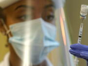 FILE - In this Jan. 8, 2021, file photo, a pharmacist prepares a syringe of the Pfizer vaccine for COVID-19, at Queen Anne Healthcare, a skilled nursing and rehabilitation facility in Seattle. With booster doses of Pfizer's COVID-19 vaccine now authorized in the U.S., government advisers reconvened on Thursday, Sept. 23, to tackle the most contentious question yet: Exactly who should roll up their sleeves right away? (AP Photo/Ted S.