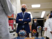 FILE - In this Feb. 11, 2021 file photo, President Joe Biden visits the Viral Pathogenesis Laboratory at the National Institutes of Health (NIH) in Bethesda, Md. This summer's coronavirus surge has been labeled a "pandemic of the unvaccinated" by government officials from President Joe Biden on down. That sound bite captures the glaring reality that unvaccinated people overwhelmingly account for new cases and serious infections.