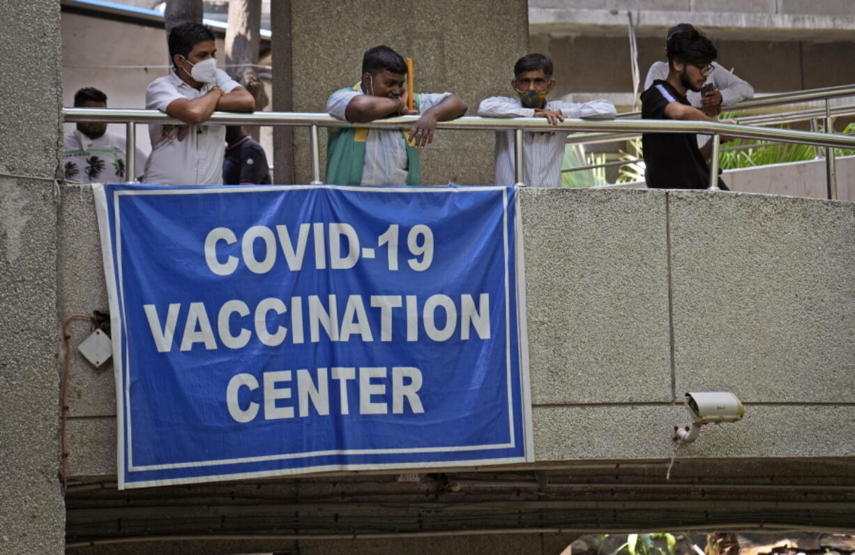 People watch others arrive to receive the COVID-19 vaccine at a government-run hospital in New Delhi, India, Tuesday, Sept. 21, 2021. Travelers and authorities from India and many African countries are furious -- and confused -- about Britain's new COVID-19 travel rules, calling them discriminatory, as experts warn the measures could fuel misinformation about vaccines in countries in some of the world's least vaccinated countries.