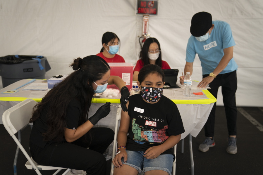 Mayra Navarrete, 13, receives the Pfizer COVID-19 vaccine from registered nurse Noleen Nobleza at a clinic set up in the parking lot of CalOptima in Orange, Calif.