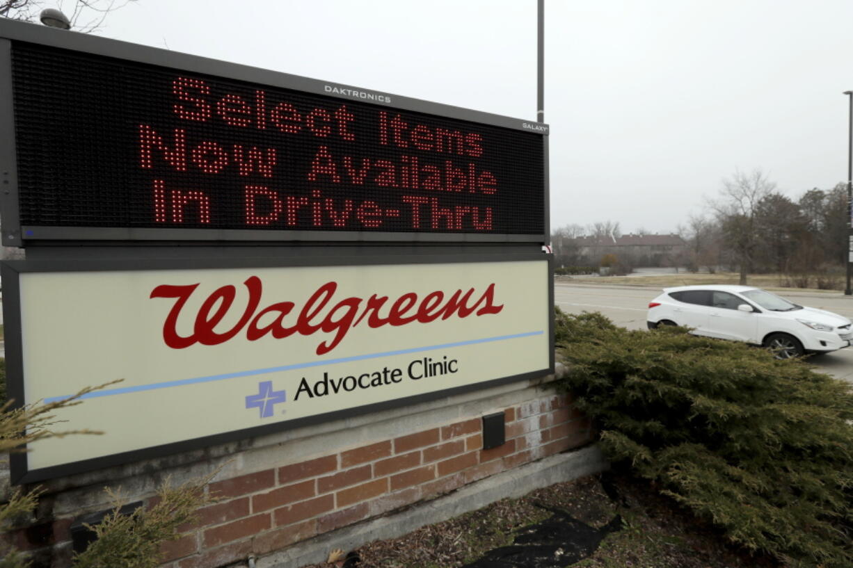 FILE - In this March 27, 2020, file photo, a Walgreens sign is displayed outside the store in Wheeling, Ill. Walgreens will hike starting pay to $15 an hour beginning in October, as employers across the United States continue boosting wages to attract workers. The drugstore chain said Tuesday, Aug. 31, 202, that the wage hike will take effect in phases and be completed by November 2022. (AP Photo/Nam Y.