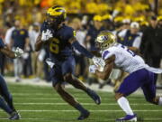 Michigan wide receiver Cornelius Johnson (6) rushes away from Washington defensive back Kyler Gordon, right, in the first quarter of an NCAA college football game in Ann Arbor, Mich., Saturday, Sept. 11, 2021.