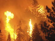 Bursts of energy go up in balls of fire after the Caldor Fire moved into the Christmas Valley and began making its way along the the South Tahoe rim towards Heavenly, Monday, Aug. 30, 2021 in South Lake Tahoe, Calif .