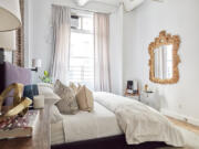 A gold mirror and gold accessories add a pop of metallic to this master bedroom.