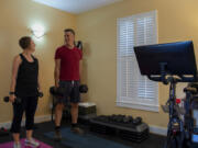 Amy Hawkins and Ben Novinger begin a workout at their home in Portland. They are participants in a OHSU's Knight Cancer Institute trial program called Exercising Together. Continuing research demonstrates that exercise is beneficial during and after cancer treatment.