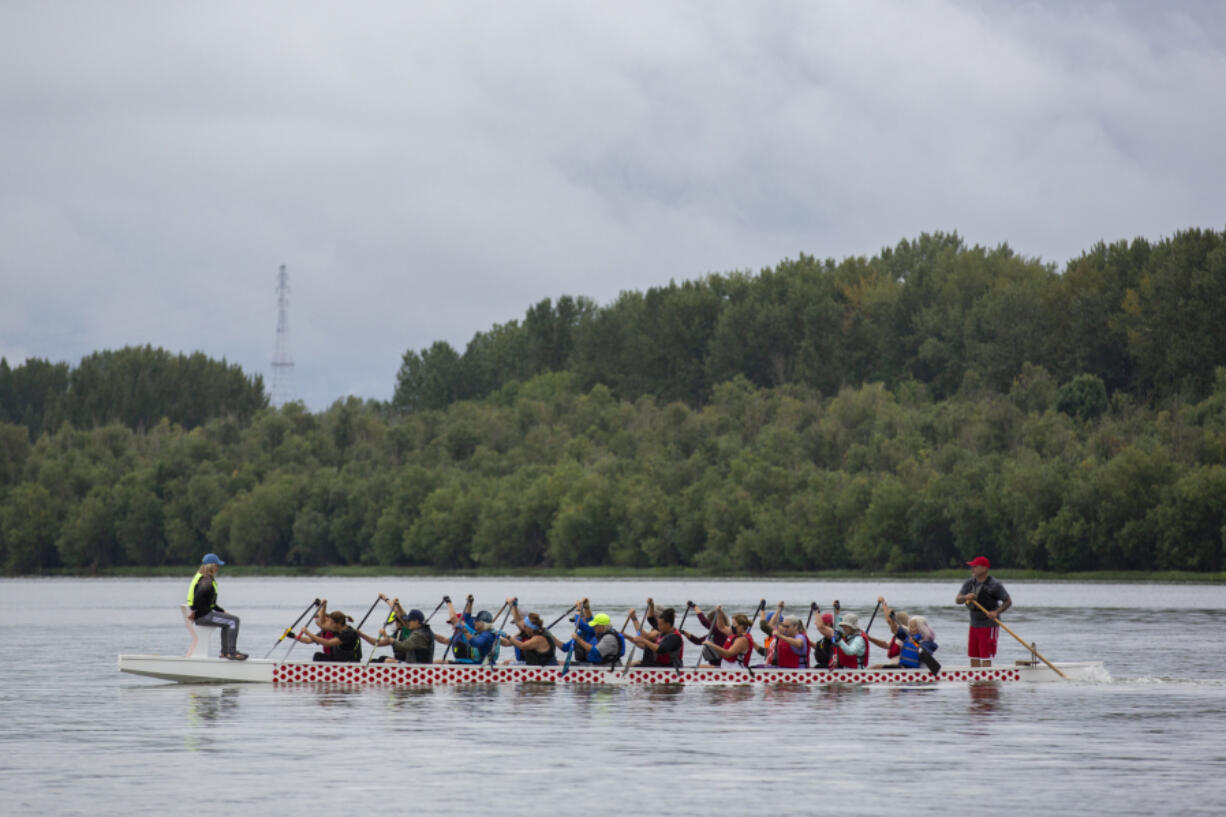 Catch-22 coaches Laura Thornquist, left, and Steve Kala, right, lead paddlers through practice on Vancouver Lake in August.