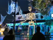 A 12-foot tall skeleton looms over people looking at Halloween decorations the Mains' house on Franklin Street in Vancouver earlier this month.