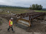 Chris Collins, project manager for the Lower Columbia Estuary Partnership, walks past a new trail bridge crossing the levee breach to the Columbia River at the Steigerwald Lake National Wildlife Refuge on Wednesday morning.