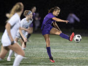 Ridgefield's Eliana Petersen (5) defends as Columbia River's Anna Iniguez (12) connects with the ball in the first half at Columbia River High School on Tuesday night, Oct. 12, 2021.