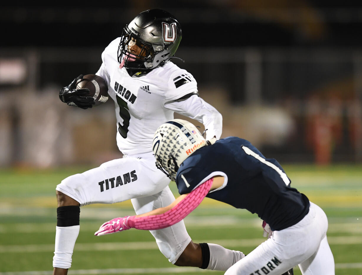 Union senior Tobias Merriweather, left, stiff arms Skyview senior Teddy Beaver on Thursday, Oct. 14, 2021, during Titans’ 37-7 loss to Skyview at the Kiggins Bowl in Vancouver.