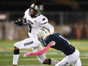 Union senior Tobias Merriweather, left, stiff arms Skyview senior Teddy Beaver on Thursday, Oct. 14, 2021, during Titans’ 37-7 loss to Skyview at the Kiggins Bowl in Vancouver.