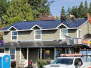 Crews install a new Tesla roof at Dave Miller's Camas home. At top: The glass photovoltaic tiles in a Tesla roof are stronger than standard roofing tiles, according to the company.