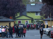 People gather at Alder Creek Apartments and Townhomes after a shooting in northeast Vancouver on Tuesday evening, Oct. 19, 2021. The apartment complex is just west of the location where Clark County sheriffs deputies fatally shot a suspect in an assault on Sunday.