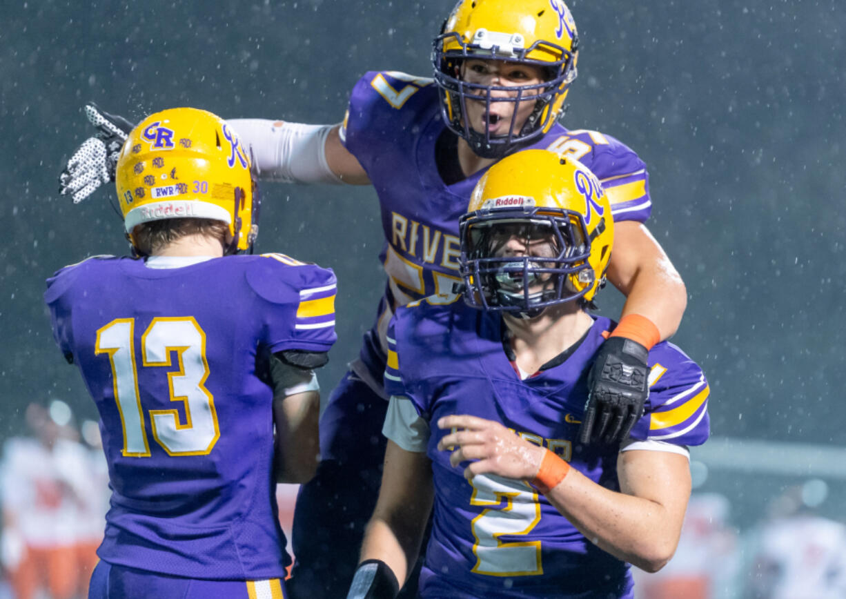 Columbia River's Diego Carrion jumps on the back of Adam Huerena, who recovered a second-half fumble, in a 2A Greater St. Helens League football game on Thursday, Oct. 21, at Kiggins Bowl. Columbia River won 16-13.