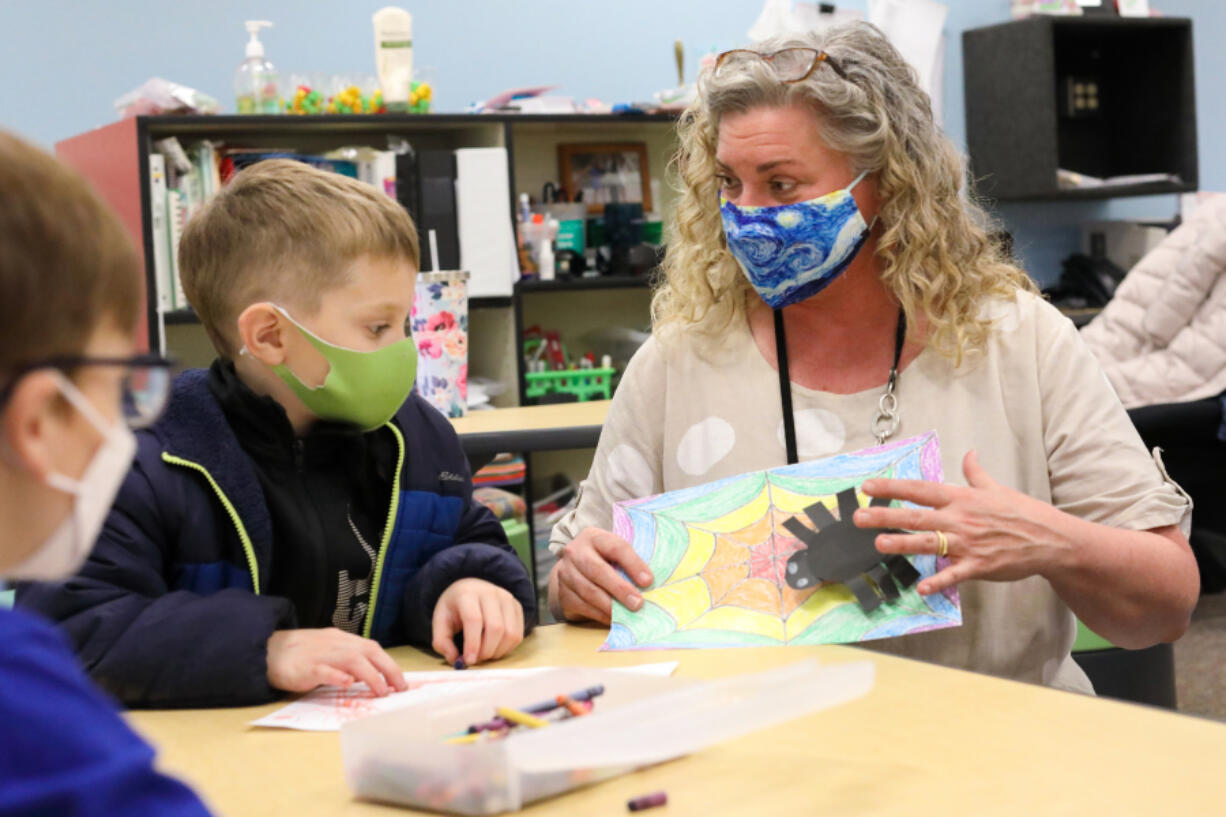 Karin Rivera, Art Discovery's coordinator, helps to put an art project together with a young student. The program teaches students a variety of art mediums and how to engage with them as a form of expression and stress release.