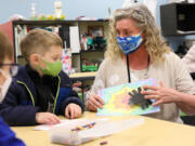 Karin Rivera, Art Discovery's coordinator, helps to put an art project together with a young student. The program teaches students a variety of art mediums and how to engage with them as a form of expression and stress release.