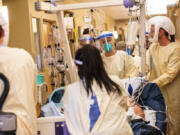 A medical team moves a COVID-19 patient to a new room in the ICU at Central Washington Hospital on Tuesday, Sept. 21, 2021.