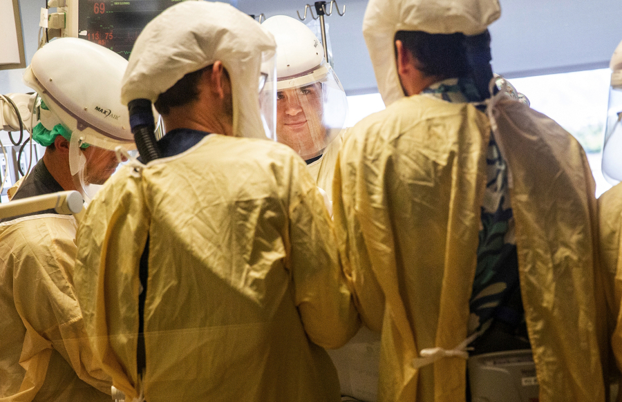 Registered Nurse Westin Prouty, center, and a medical team finish turning over a COVID-19 patient onto their stomach to help with breathing, inside the intensive care unit at Central Washington Hospital on Tuesday, Sept. 21, 2021. Proning, or turning a patient on their stomach for better breathing, takes a team of people. With staffing shortages, the hospital has trained staff in other departments to come help with this strenuous and time-consuming process.