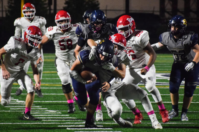 Seton Catholic's Jack Callerame (23) tries to escape a tackle from a group of Castle Rock Rockets.