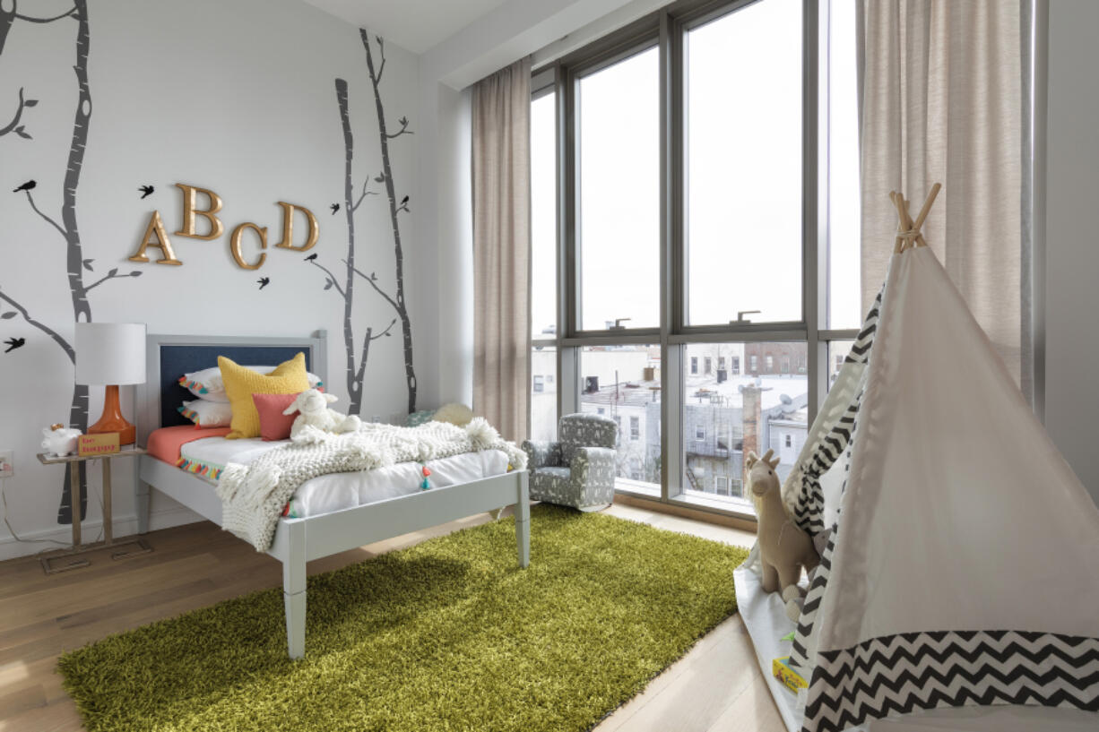 A table lamp and bedding blending various citrus colors is paired with a bright lime area rug in this child-inspired space.